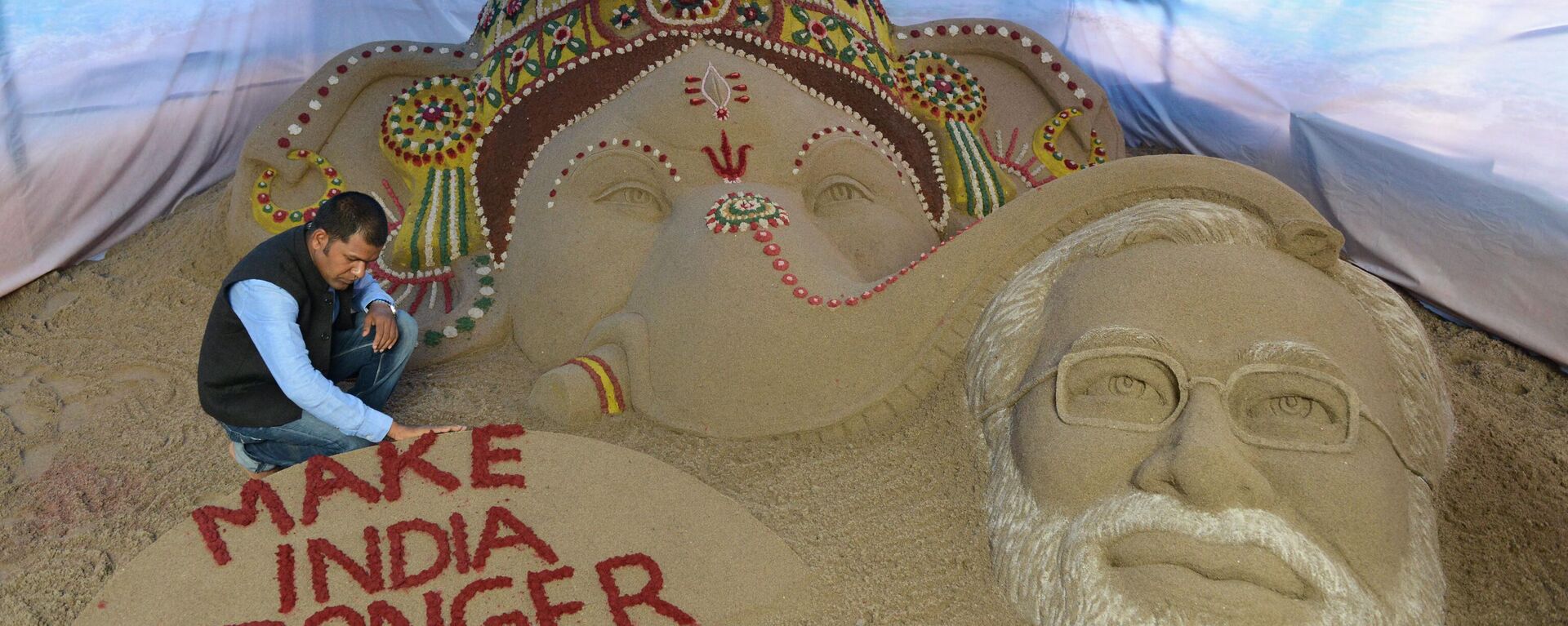 Indian sand artist Sudarsan Pattnaik makes finishing touches of a commissioned sand sculpture of Hindu god Lord Ganesha blessing Indian Prime Minister Narendra Modi at a Ganesh Pandal in Surat, some 265 kms from Ahmedabad, on August 28, 2014. - Sputnik India, 1920, 15.10.2023