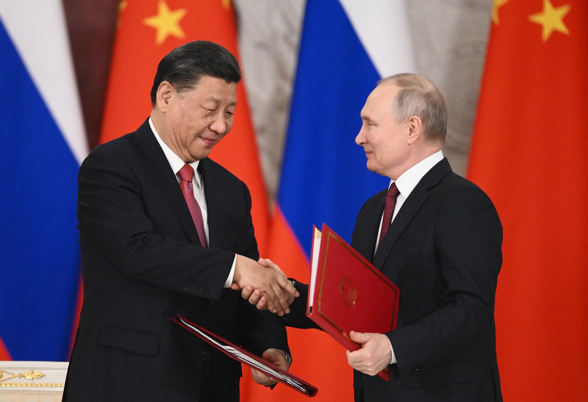 Chinese Leader Xi Jinping and Russian President Vladimir Putin shake hands after signing a joint statement on deepening comprehensive partnership and strategic cooperation and on the plan for development of key areas of the economic cooperation until 2030 at the Kremlin, in Moscow, Russia. - Sputnik India, 1920, 06.12.2023