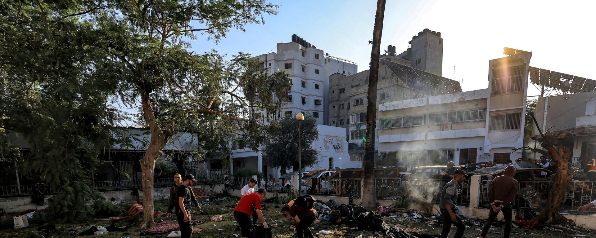 People search through debris outside the site of the Ahli Arab hospital in central Gaza on October 18, 2023 in the aftermath of an overnight blast there.  - Sputnik भारत, 1920, 19.10.2023