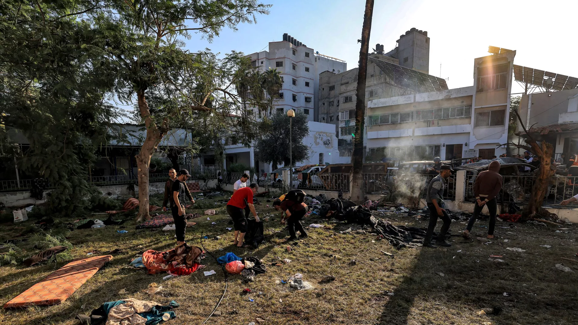 People search through debris outside the site of the Ahli Arab hospital in central Gaza on October 18, 2023 in the aftermath of an overnight blast there. 