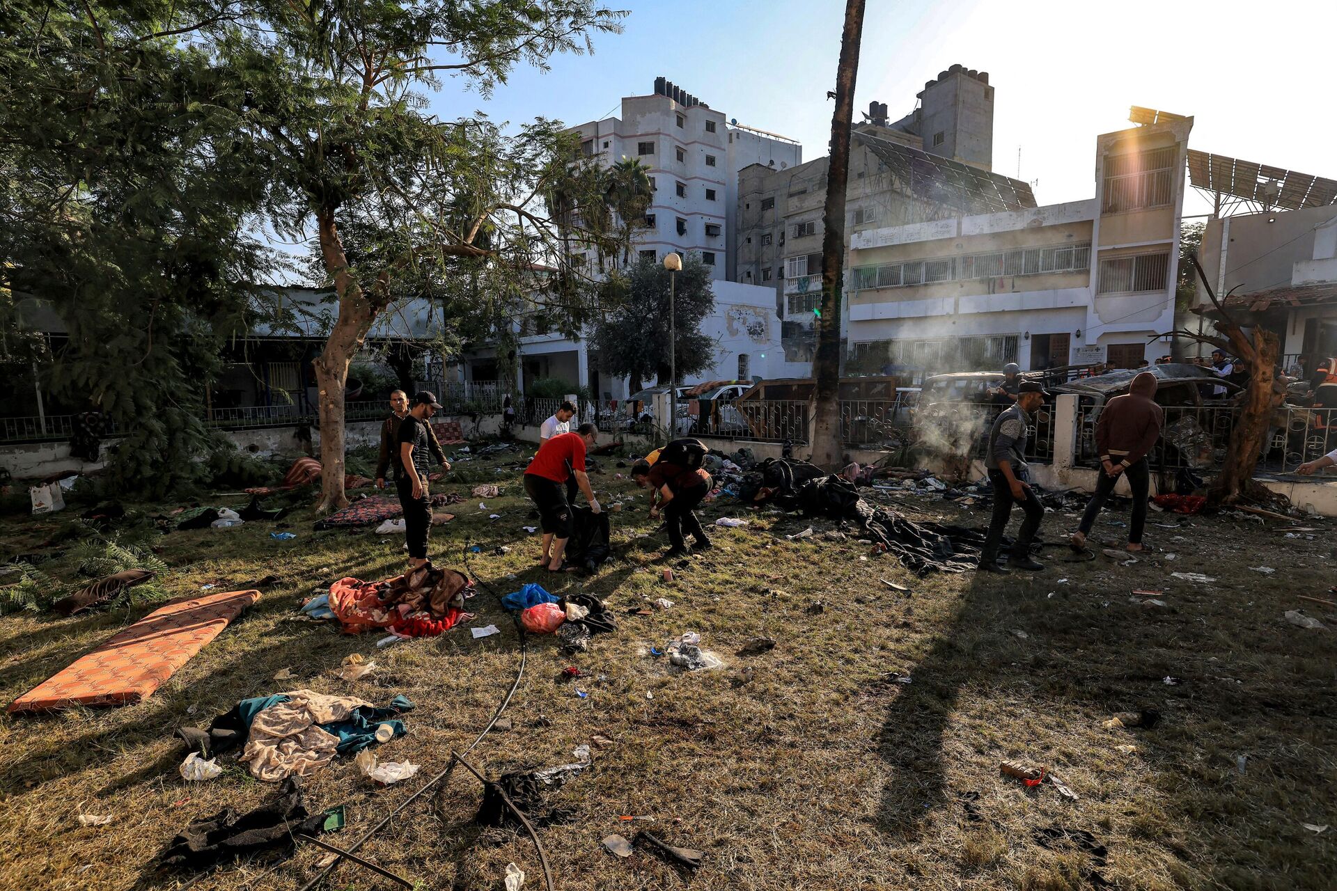 People search through debris outside the site of the Ahli Arab hospital in central Gaza on October 18, 2023 in the aftermath of an overnight blast there.  - Sputnik भारत, 1920, 18.10.2023