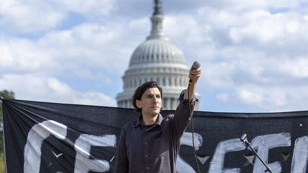 Performer Morgan Bassichis holds up the microphone during a demonstration calling for a ceasefire in Gaza near the Capitol in Washington on Wednesday, Oct. 18, 2023 - Sputnik India