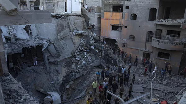 Palestinians search for survivors from a building destroyed in Israeli bombardment in Khan Younis, Gaza Strip, Thursday, Oct. 19, 2023 - Sputnik भारत