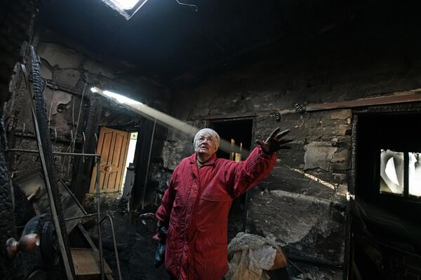 &quot;We just have to wait&quot;, 2nd place, Taisia Vorontsova (Russia). Top News, series.An elderly woman standing in her neighbour’s burnt-out house in Yelenovka, a village near Donetsk. A Ukrainian projectile directly hit the roof, and the house immediately caught fire. Fortunately, the owner survived. - Sputnik India