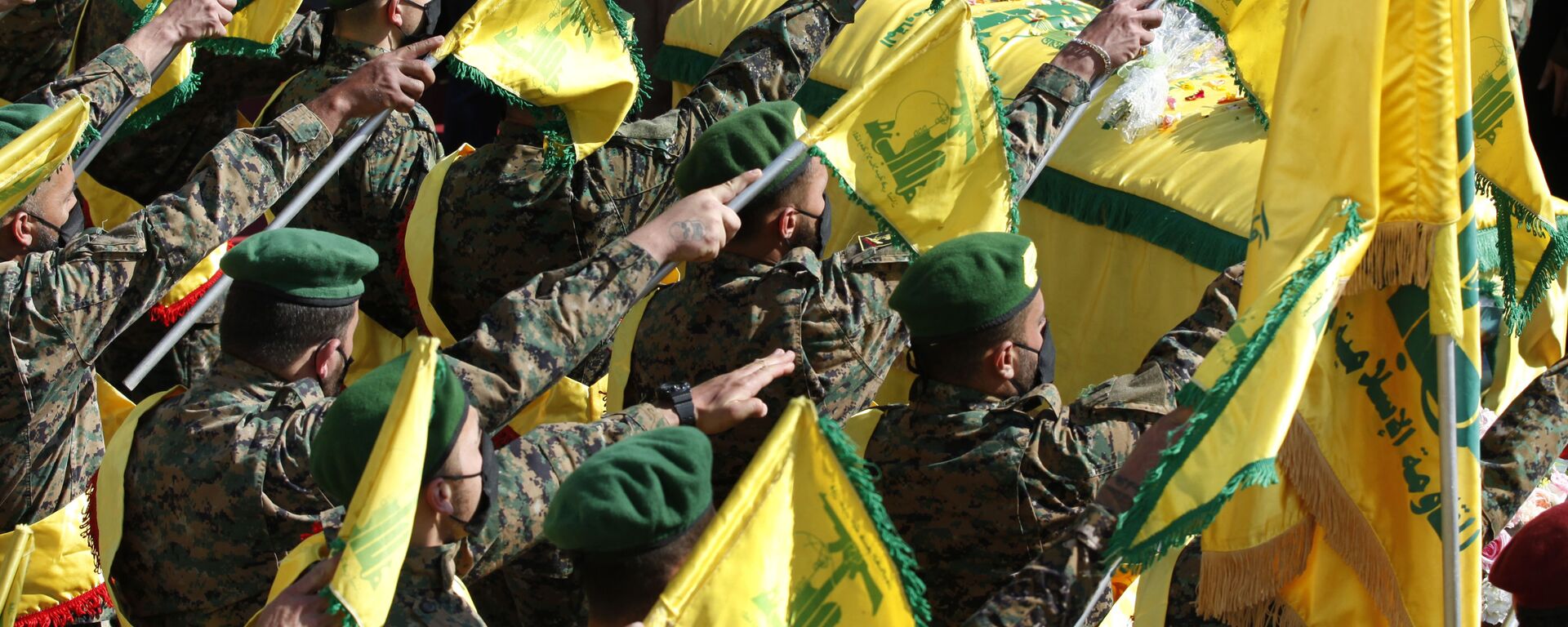Hezbollah fighters raise their group flags, as they salut the coffin of their comrade Mohammed Tahhan who was shot dead on Friday by Israeli forces along the Lebanon-Israel border, during his funeral procession, in the southern village of Adloun, Lebanon, Saturday, May 15, 2021 - Sputnik India, 1920, 22.10.2023