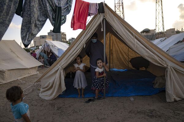 गाजा पट्टी पर इजराइली बमबारी से विस्थापित फिलिस्तीनी बच्चे गुरुवार, 19 अक्टूबर को खान यूनिस में यूएनडीपी द्वारा प्रदान किए गए तम्बू शिविर में हैं (एपी फोटो/फातिमा शबैर) - Sputnik भारत