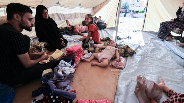 Члены семьи сидят в одной из палаток в Хан-Юнисе, Палестина - Sputnik India
