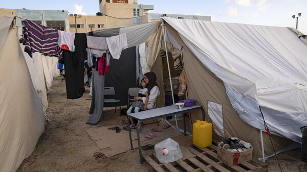 Палестинцы, перемещенные в результате израильской бомбардировки сектора Газа, в палаточном лагере - Sputnik भारत