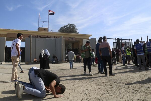शनिवार, 21 अक्टूबर, 2023 को गाजा पट्टी के लिए मानवीय सहायता ले जाने वाले ट्रकों के राफा, मिस्र में राफा सीमा द्वार को पार करने के बाद स्वयंसेवक भगवान को धन्यवाद देने के लिए प्रार्थना करते हैं। (AP Photo/Mohammed Asad) - Sputnik भारत