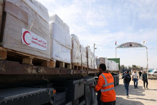 लोग मानवीय सहायता ले जाने वाले ट्रकों के आसपास इकट्ठा होते हैं जो 21 अक्टूबर, 2023 को राफा सीमा पार के माध्यम से मिस्र से गाजा पट्टी में प्रवेश कर गए हैं। (Photo by Mohammed ABED / AFP) - Sputnik भारत