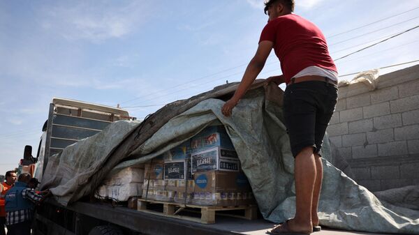 Рабочий организует доставку продовольственной помощи после того, как колонна грузовиков въехала на палестинскую сторону через КПП Рафах - Sputnik भारत