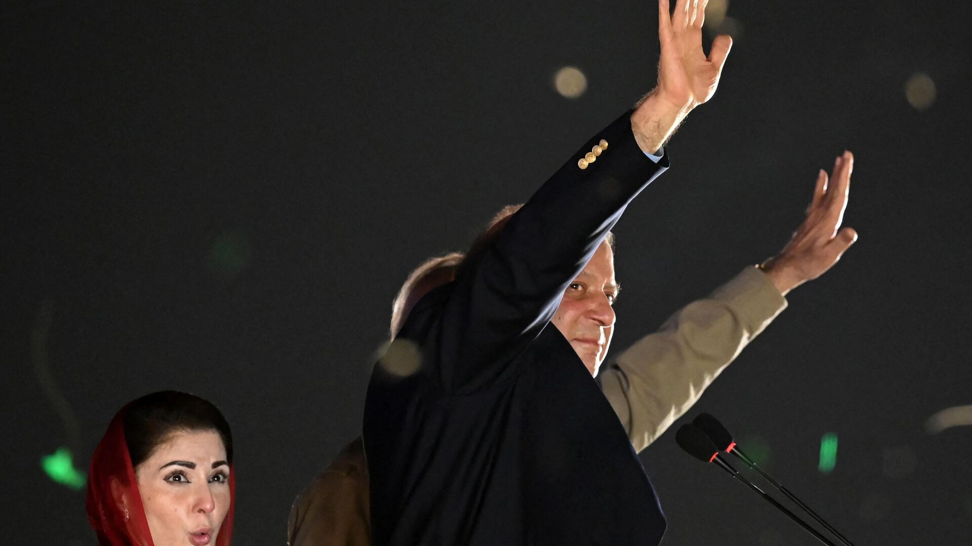 Pakistan's former Prime Minister Nawaz Sharif (R) waves to his supporters gathered at a park as his daughter Maryam Nawaz (L) reacts during an event held to welcome the former in Lahore on October 21, 2023. - Sputnik भारत, 1920, 22.10.2023