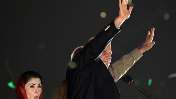 Pakistan's former Prime Minister Nawaz Sharif (R) waves to his supporters gathered at a park as his daughter Maryam Nawaz (L) reacts during an event held to welcome the former in Lahore on October 21, 2023. - Sputnik भारत