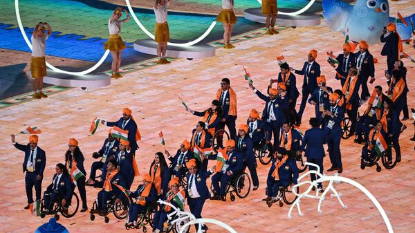 India's delegation wave their country's national flag as they take part in the athletes parade during the opening ceremony of the 2022 Asian Para Games at the Hangzhou Olympic Sports Centre Stadium in Hangzhou in China's eastern Zhejiang province on October 22, 2023.  - Sputnik India