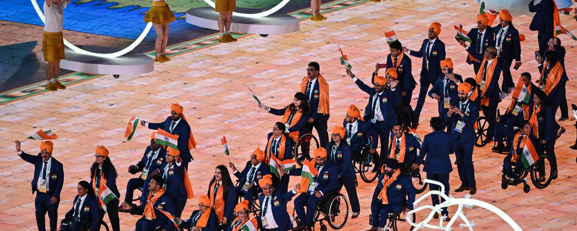 India's delegation wave their country's national flag as they take part in the athletes parade during the opening ceremony of the 2022 Asian Para Games at the Hangzhou Olympic Sports Centre Stadium in Hangzhou in China's eastern Zhejiang province on October 22, 2023.  - Sputnik India, 1920, 23.10.2023