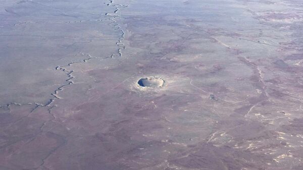 The Meteor Crater near Winslow, Arizona, is seen from a plane Januray 30, 2017. The Meteor Crater, sometimes known as the Barringer Crater and formerly as the Canyon Diablo crater, is a famous impact crater. It is the breath-taking result of a collision between an asteroid traveling 26,000 miles per hour and planet Earth approximately 50,000 years ago. Meteor Crater is nearly one mile across, 2.4 miles in circumference and more than 550 feet deep. - Sputnik India