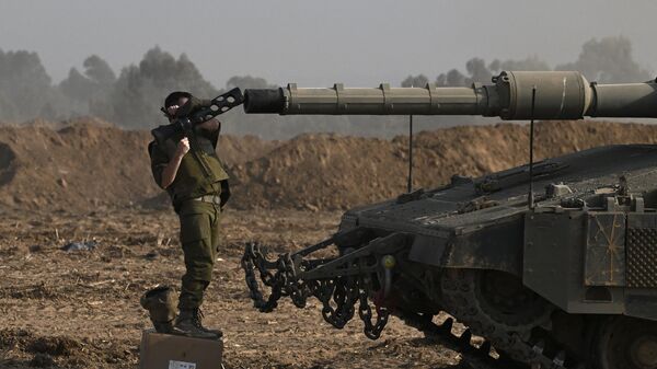 An Israeli solider checks the gun of a Merkava tank deployed along Israel's border with Gaza on October 24, 2023, amid the ongoing battles between Israel and the Palestinian group Hamas. - Sputnik India
