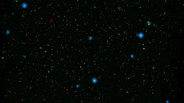 The blue dots in this field of galaxies, known as the COSMOS field, show galaxies that contain supermassive black holes emitting high-energy X-rays - Sputnik भारत