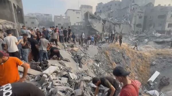 This image grab taken from AFPTV video footage shows Palestinians looking for survivors in a crater following a stike on the Jabaliya refugee camp in the northern Gaza Strip, on October 31, 2023. - Sputnik भारत