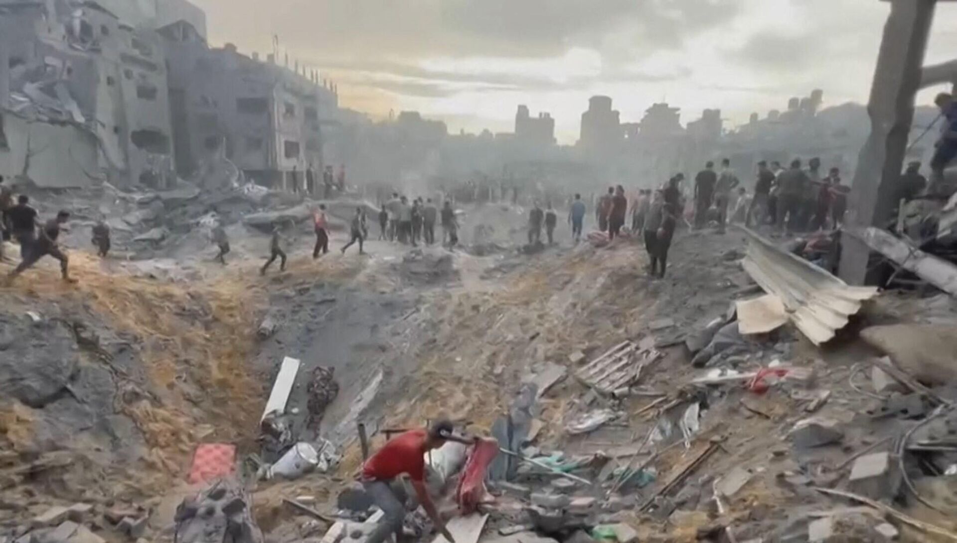 This image grab taken from AFPTV video footage shows Palestinians looking for survivors in a crater following a stike on the Jabaliya refugee camp in the northern Gaza Strip, on October 31, 2023. - Sputnik भारत, 1920, 01.11.2023