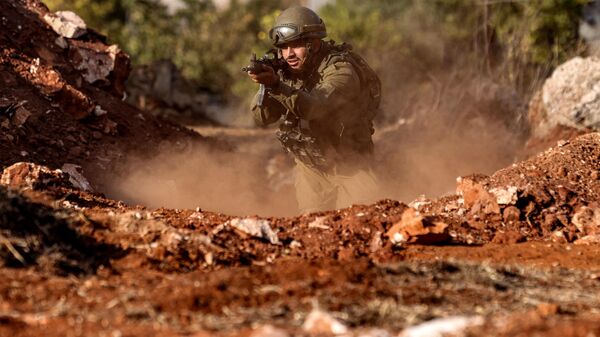 An Israeli army soldier advances during a drill at a position in the upper Galilee region of northern Israel near the border with Lebanon - Sputnik भारत