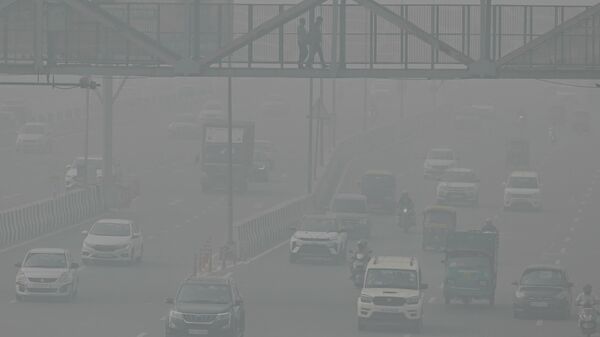 Commuters make their way along a road amid heavy smoggy conditions in New Delhi on November 5, 2023. Authorities in the smog-ridden Indian capital New Delhi on November 5 extended an emergency schools closure by a week, with no signs of improvement in the megacity's choking levels of pollution.  - Sputnik India