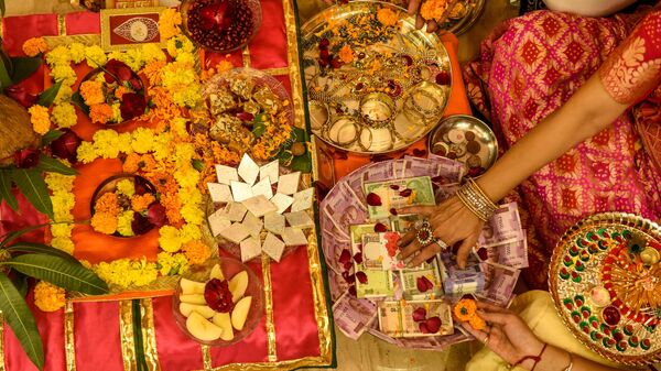 A family participates in a ritual for Dhanteras marking the day before Diwali, the Hindu festival of light, in Ahmedabad on November 13, 2020. - Sputnik India