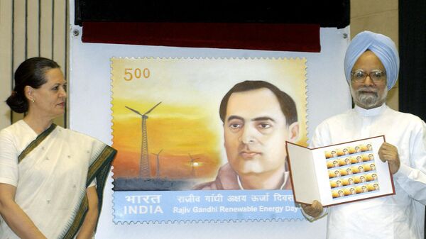Indian Prime Minister Manmohan Singh (R) holds the newly released  postal stamp of the Ministry of Non-conventional Energy Sources to mark former Prime Minister Rajiv Gandhi's 60th birth anniversary as UPA chairperson, Congress President and Rajiv's widow Sonia Gandhi (L) looks on during a function in New Delhi, 20 August 2004. - Sputnik India