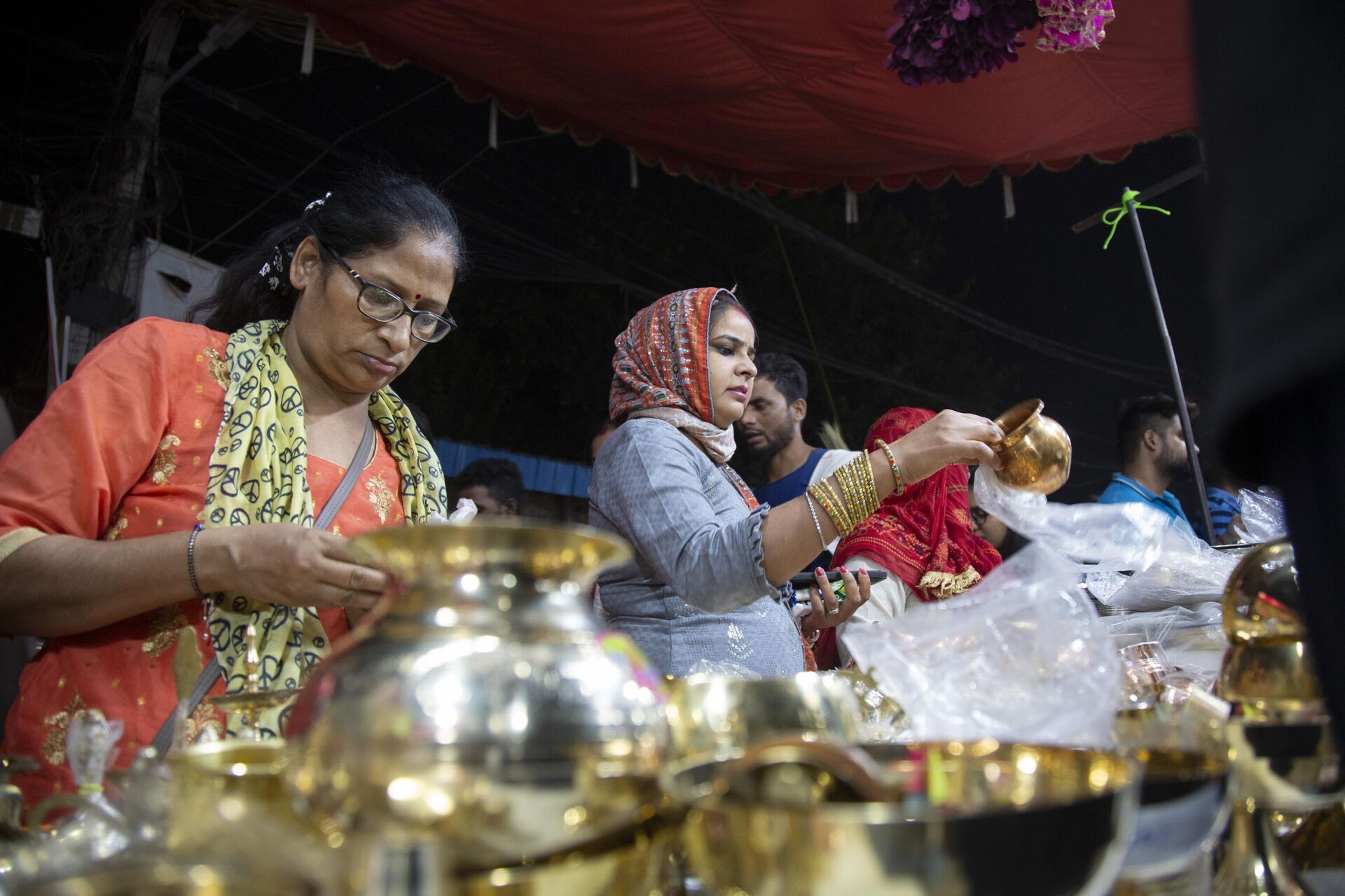 People buy utensils as they mark 'Dhanteras', a day considered auspicious to make new purchases ahead of Diwali festival in New Delhi, India, Saturday. Oct. 22, 2022. - Sputnik India, 1920, 09.11.2023