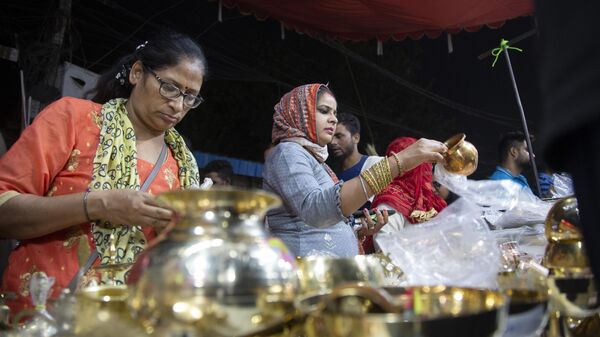 People buy utensils as they mark 'Dhanteras', a day considered auspicious to make new purchases ahead of Diwali festival in New Delhi, India, Saturday. Oct. 22, 2022. - Sputnik India