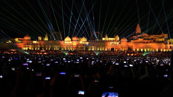 Spectators lift their phones to record a laser show on the life of Hindu God Ram on the eve of Diwali festival in Ayodhya, India. Sunday , Oct. 23, 2022.  - Sputnik भारत