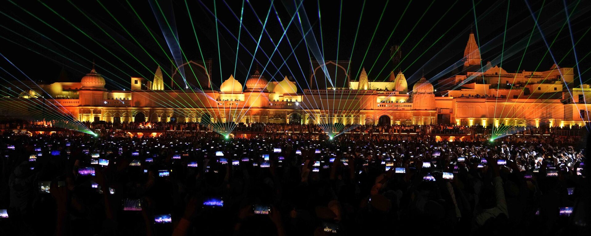 Spectators lift their phones to record a laser show on the life of Hindu God Ram on the eve of Diwali festival in Ayodhya, India. Sunday , Oct. 23, 2022.  - Sputnik भारत, 1920, 09.11.2023