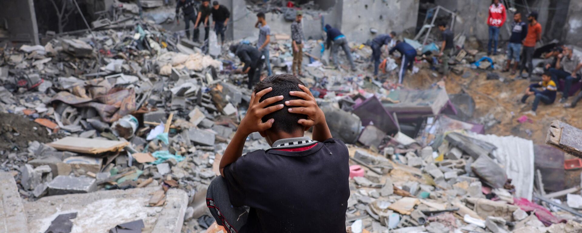 A child reacts as people salvage belongings amid the rubble of a damaged building following strikes on Rafah in the southern Gaza Strip. - Sputnik भारत, 1920, 14.11.2023