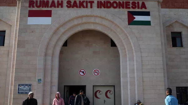 Palestinians stand outside the Indonesian Hospital in Beit Lahia in the northern Gaza Strip on January 13, 2016. The Indonesian Hospital, which is the first new hospital in a decade in the Palestinian enclave, was funded by an Indonesian NGO and opened its doors at the end of 2015. - Sputnik India
