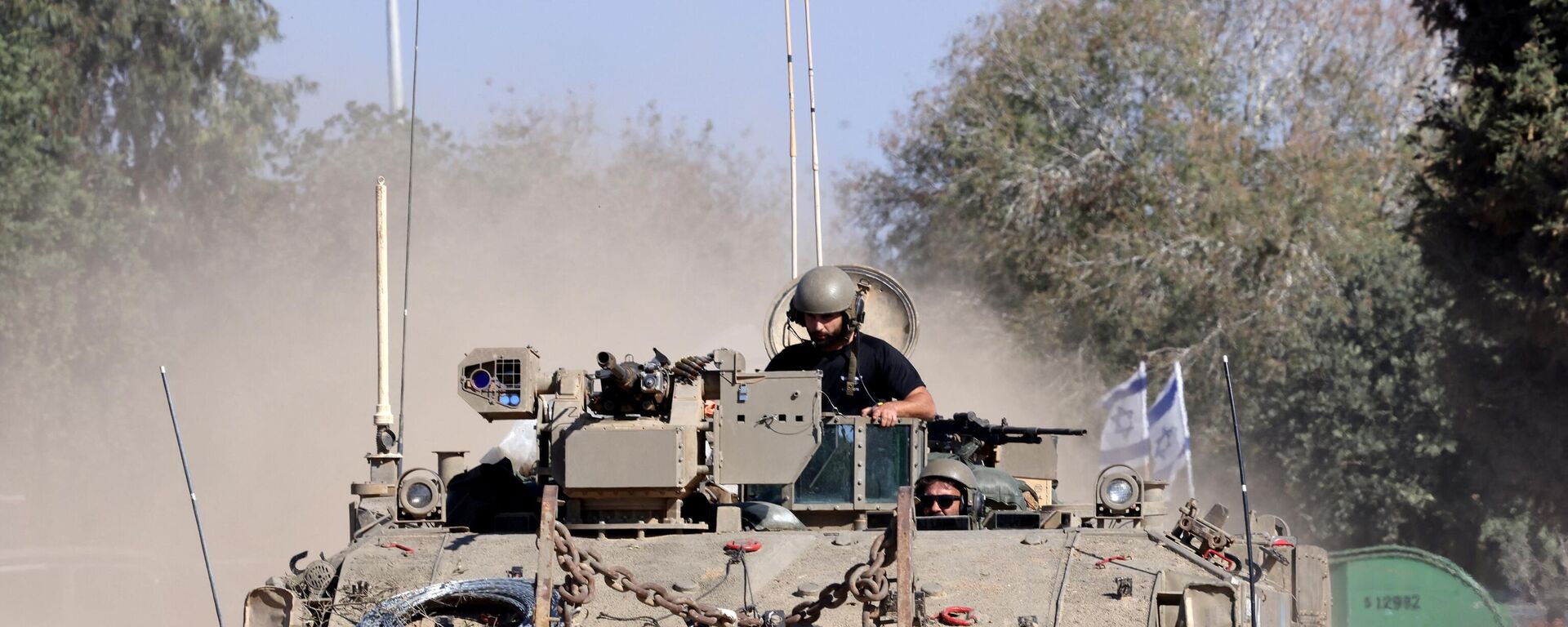 Israeli soldiers ride in an armoured vehicle as it moves into positioned close to the Israel's border with the Gaza Strip, in southern Israel on November 16, 2023. - Sputnik भारत, 1920, 17.11.2023