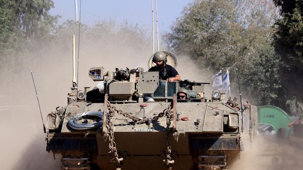Israeli soldiers ride in an armoured vehicle as it moves into positioned close to the Israel's border with the Gaza Strip, in southern Israel on November 16, 2023. - Sputnik भारत