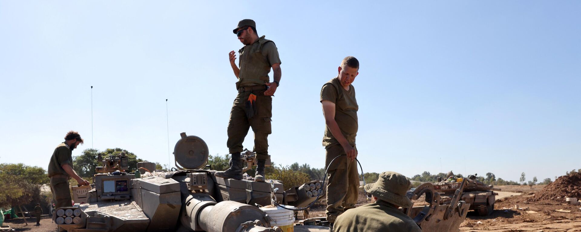 Israeli soldiers stand on their tank positioned close to the Israel's border with the Gaza Strip, in southern Israel on November 16, 2023. - Sputnik भारत, 1920, 23.11.2023