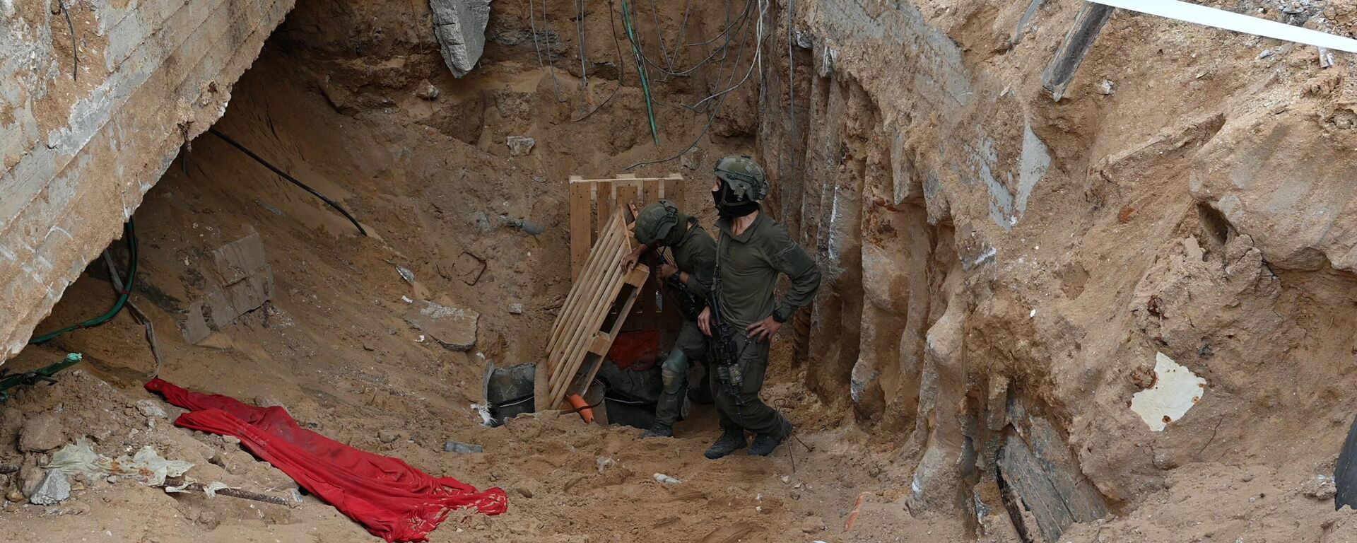 Солдаты стоят рядом с тем, что, по словам израильской армии, является входом в туннель, вырытый боевиками ХАМАС - Sputnik भारत, 1920, 23.11.2023