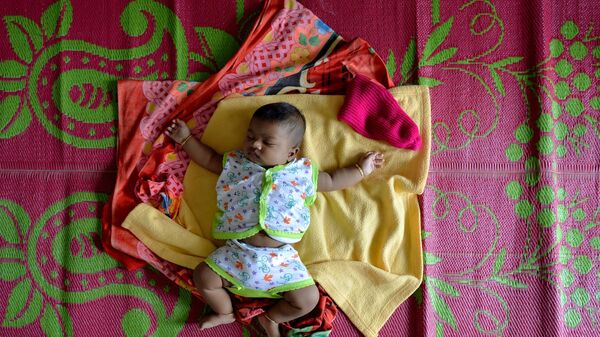 A baby sleeps on a mat at a relief camp for families displaced by flooding in Aluva on the outskirts of Kochi in the south Indian state of Kerala on August 20, 2018.  - Sputnik India