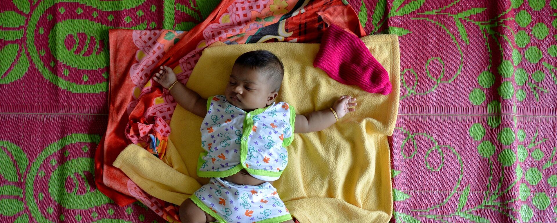 A baby sleeps on a mat at a relief camp for families displaced by flooding in Aluva on the outskirts of Kochi in the south Indian state of Kerala on August 20, 2018.  - Sputnik India, 1920, 23.11.2023