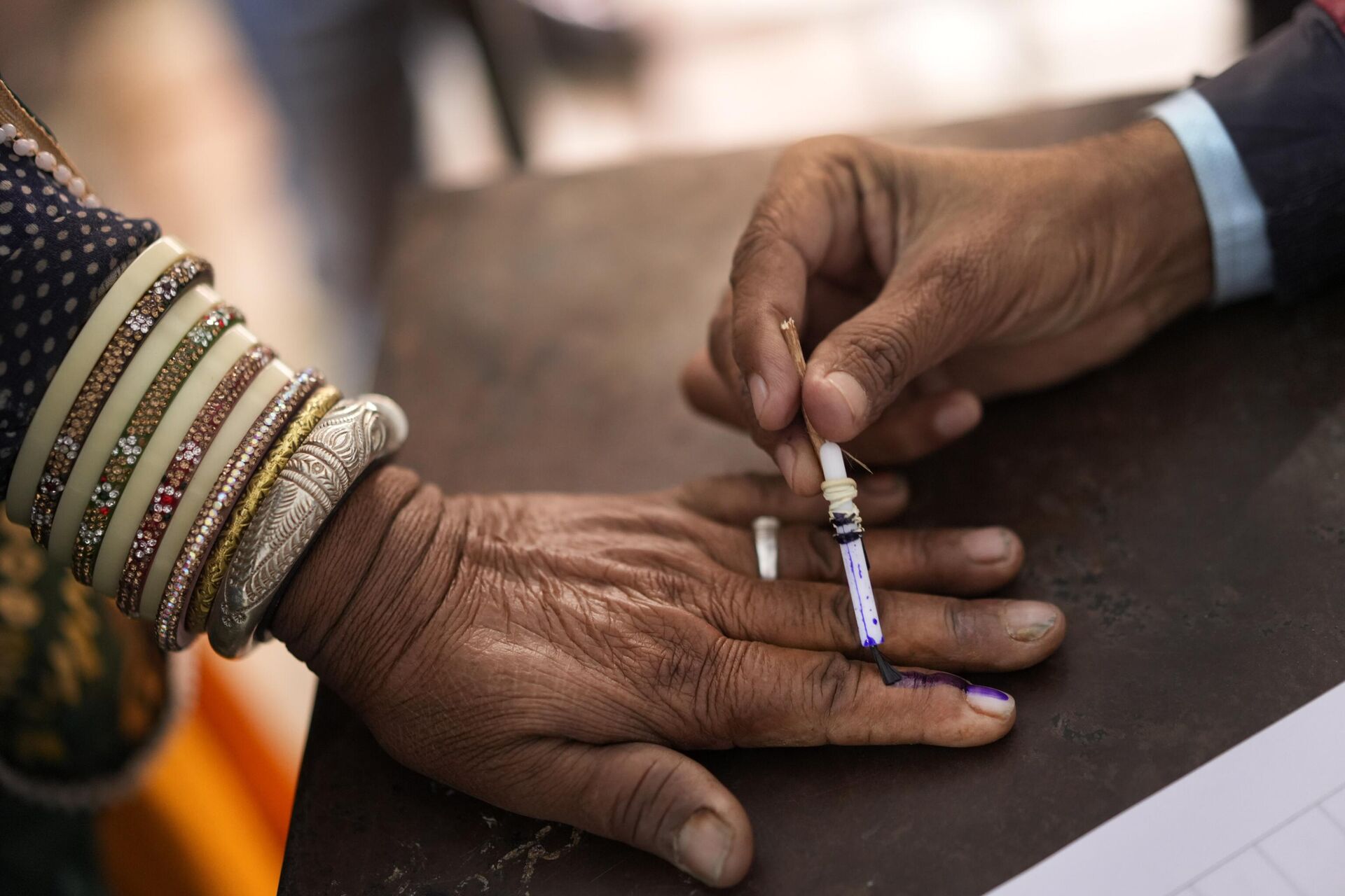 An election officer puts the indelible ink mark on the finger of a voter in Chachiyawas, near Ajmer, India, Saturday, Nov. 25, 2023. - Sputnik भारत, 1920, 02.01.2024