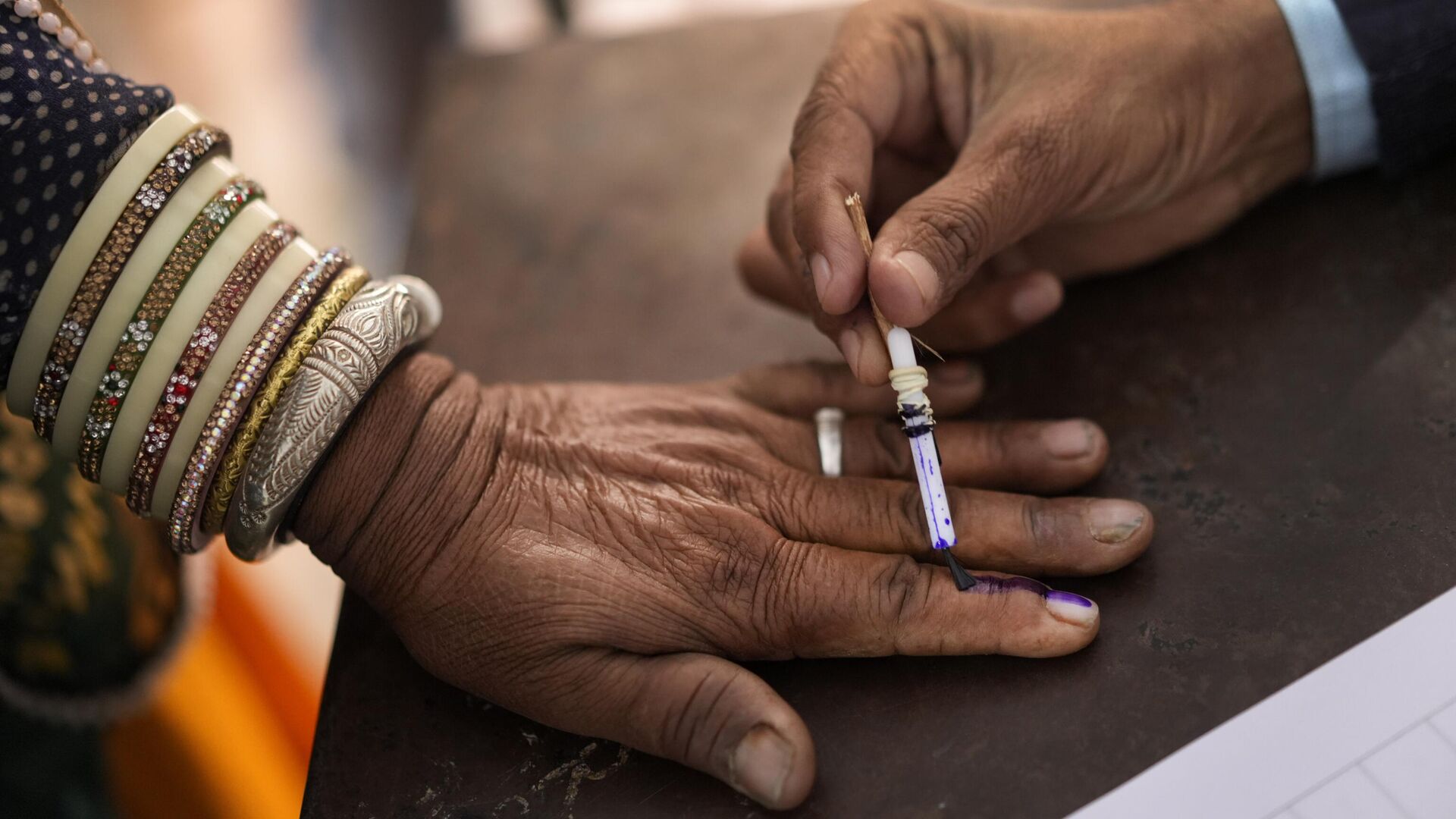 An election officer puts the indelible ink mark on the finger of a voter in Chachiyawas, near Ajmer, India, Saturday, Nov. 25, 2023. - Sputnik भारत, 1920, 04.12.2023