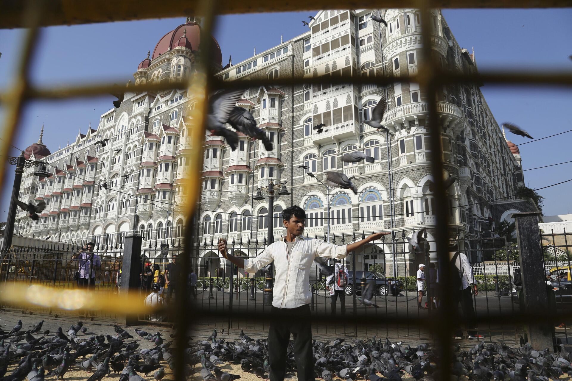 In this Nov 17, 2018, photo, a man feeds pigeons outside the iconic Taj Mahal Palace hotel, the epicenter of the 2008 terror attacks that killed 166 people in Mumbai, India. - Sputnik India, 1920, 26.11.2023