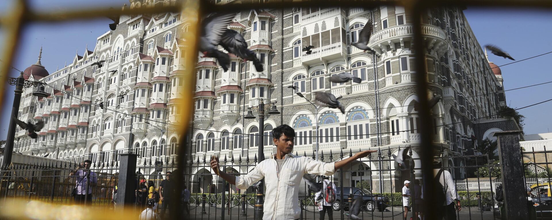 In this Nov 17, 2018, photo, a man feeds pigeons outside the iconic Taj Mahal Palace hotel, the epicenter of the 2008 terror attacks that killed 166 people in Mumbai, India. - Sputnik भारत, 1920, 26.11.2023