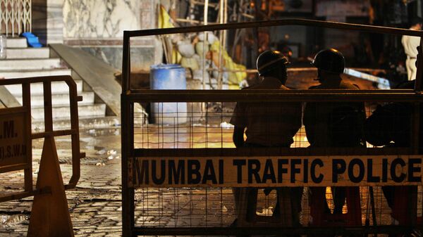 Indian policemen sit guard behind barricades at Zaveri bazar, the site of an explosion in Mumbai, India, early Thursday, July 14, 2011. - Sputnik India