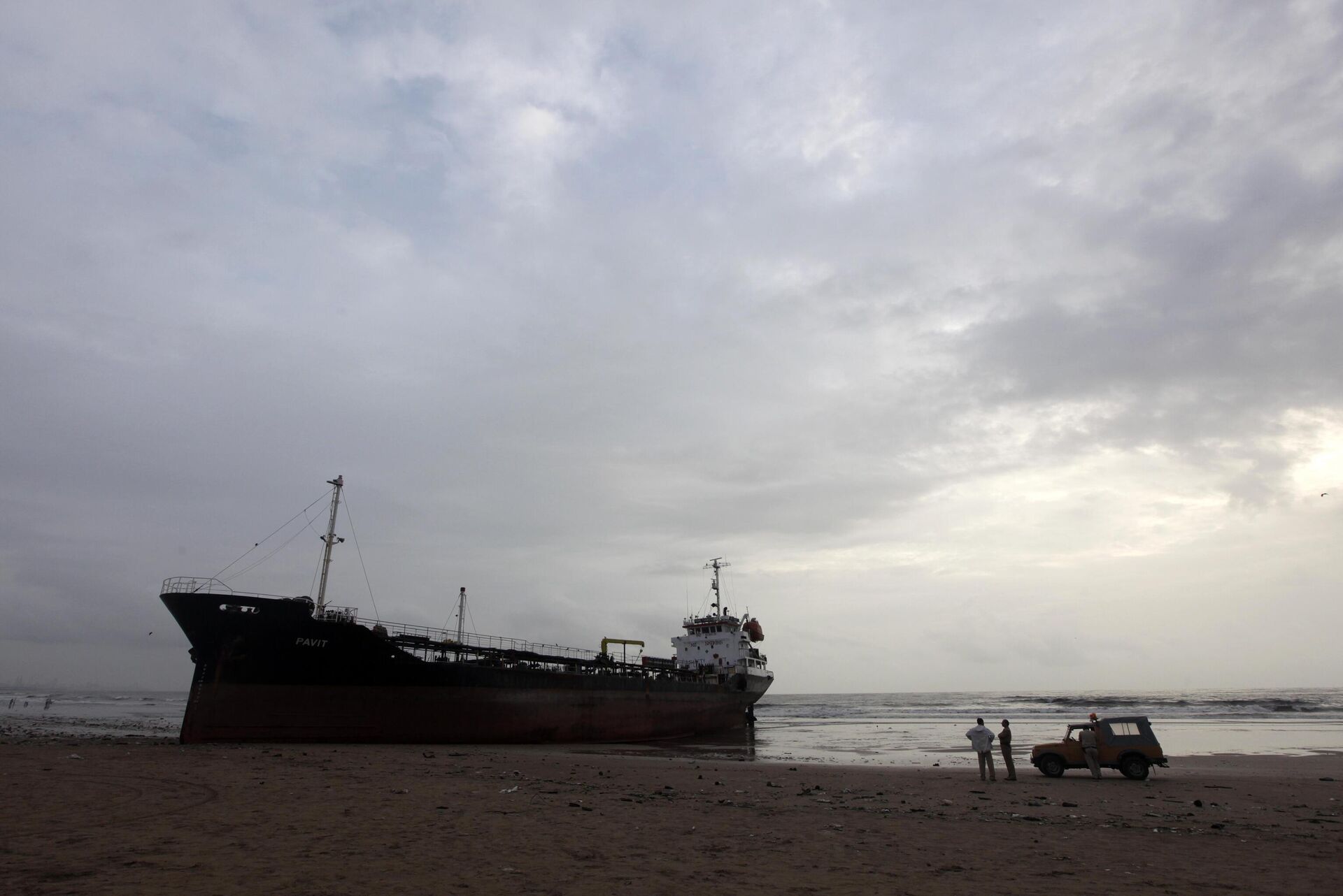 Indian policemen stand near MT Pavit, an unmanned Panama-flagged cargo vessel,that ran aground Sunday at Juhu beach on the Arabian Sea coast in Mumbai, India, Monday, Aug.1, 2011. - Sputnik India, 1920, 16.02.2024