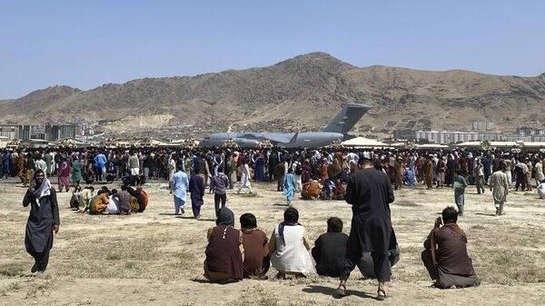 Hundreds of people gather near a U.S. Air Force C-17 transport plane at a perimeter at the international airport in Kabul, Afghanistan, Monday, Aug. 16, 2021. - Sputnik भारत