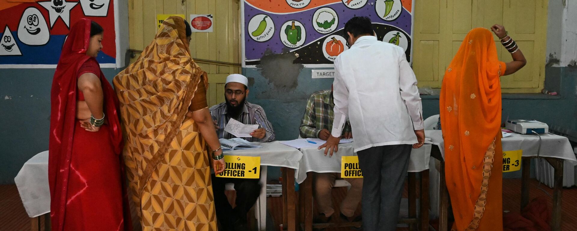 Voters check their names with polling officers prior casting their vote at a polling station during Telangana's state assembly elections in Hyderabad on November 30, 2023. - Sputnik भारत, 1920, 03.12.2023