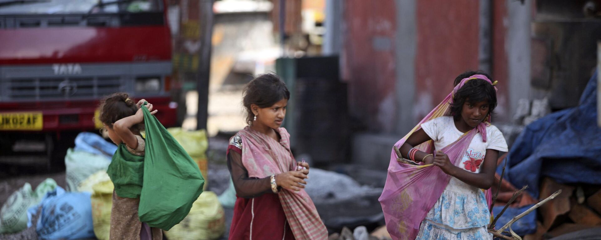 Ragpicker children carry recyclable material and walk at a yard on the outskirts of Jammu, India, Wednesday, Aug. 29, 2012. - Sputnik India, 1920, 03.12.2023