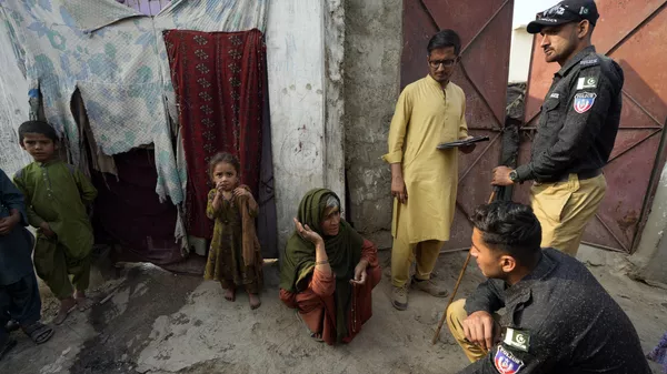 Pakistani police officers conducts biometric identification of a resident during a search operation against illegal immigrants at a neighbourhood of Karachi, Pakistan, Tuesday, Nov. 21, 2023. - Sputnik भारत